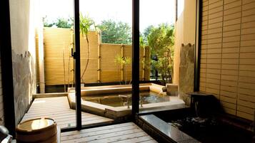 A traditional Japanese onsen with wooden flooring and a bamboo fence.