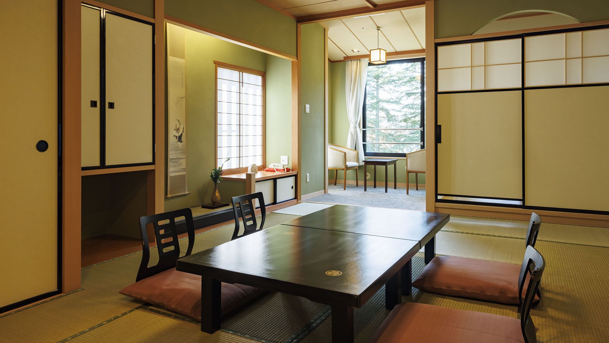 Une pièce de style japonais traditionnel, avec un sol recouvert de tatamis, une table basse et des portes coulissantes.