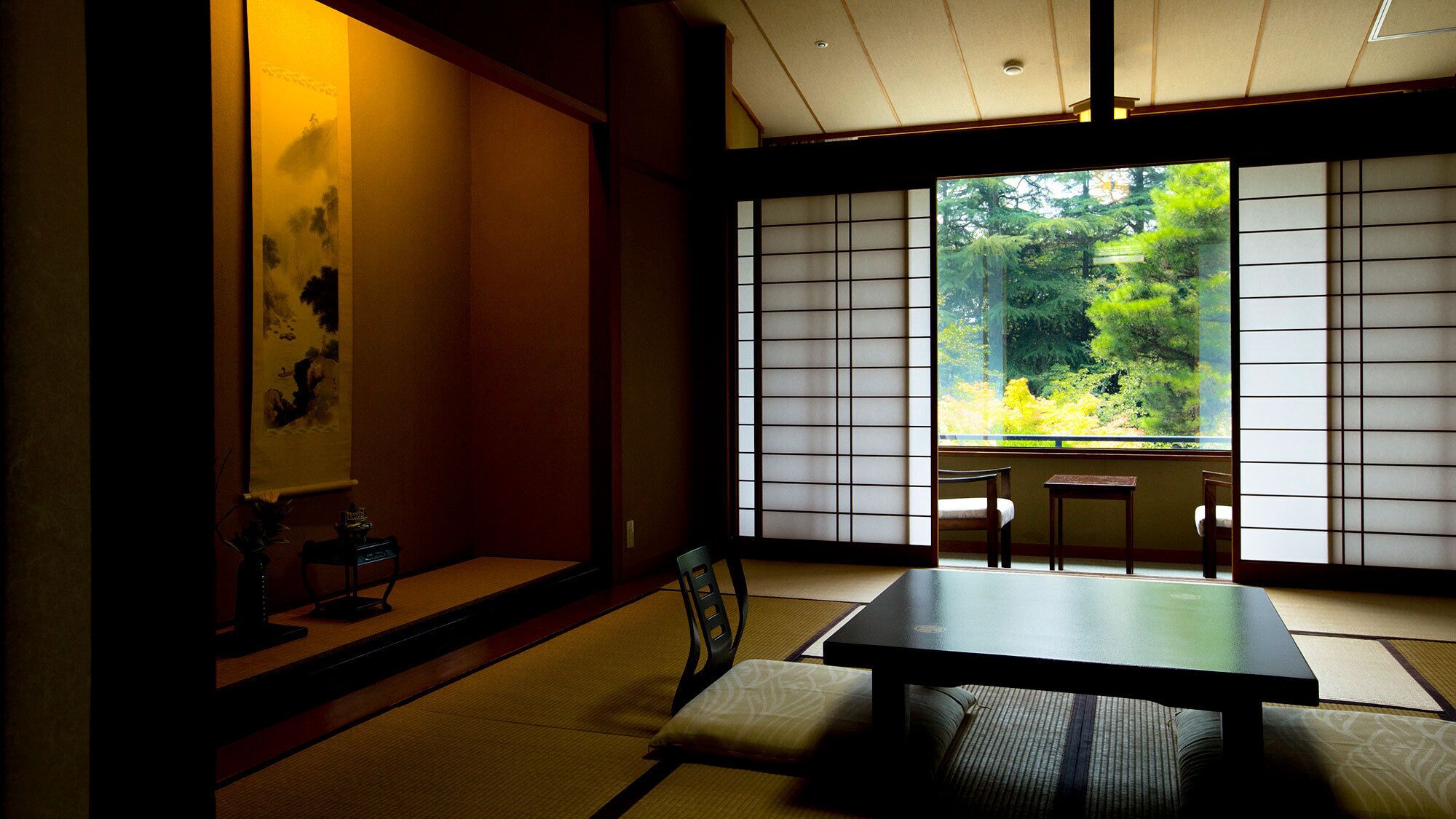 Une pièce de style japonais traditionnel, avec un sol recouvert de tatamis, une table basse et des portes coulissantes donnant sur une forêt.