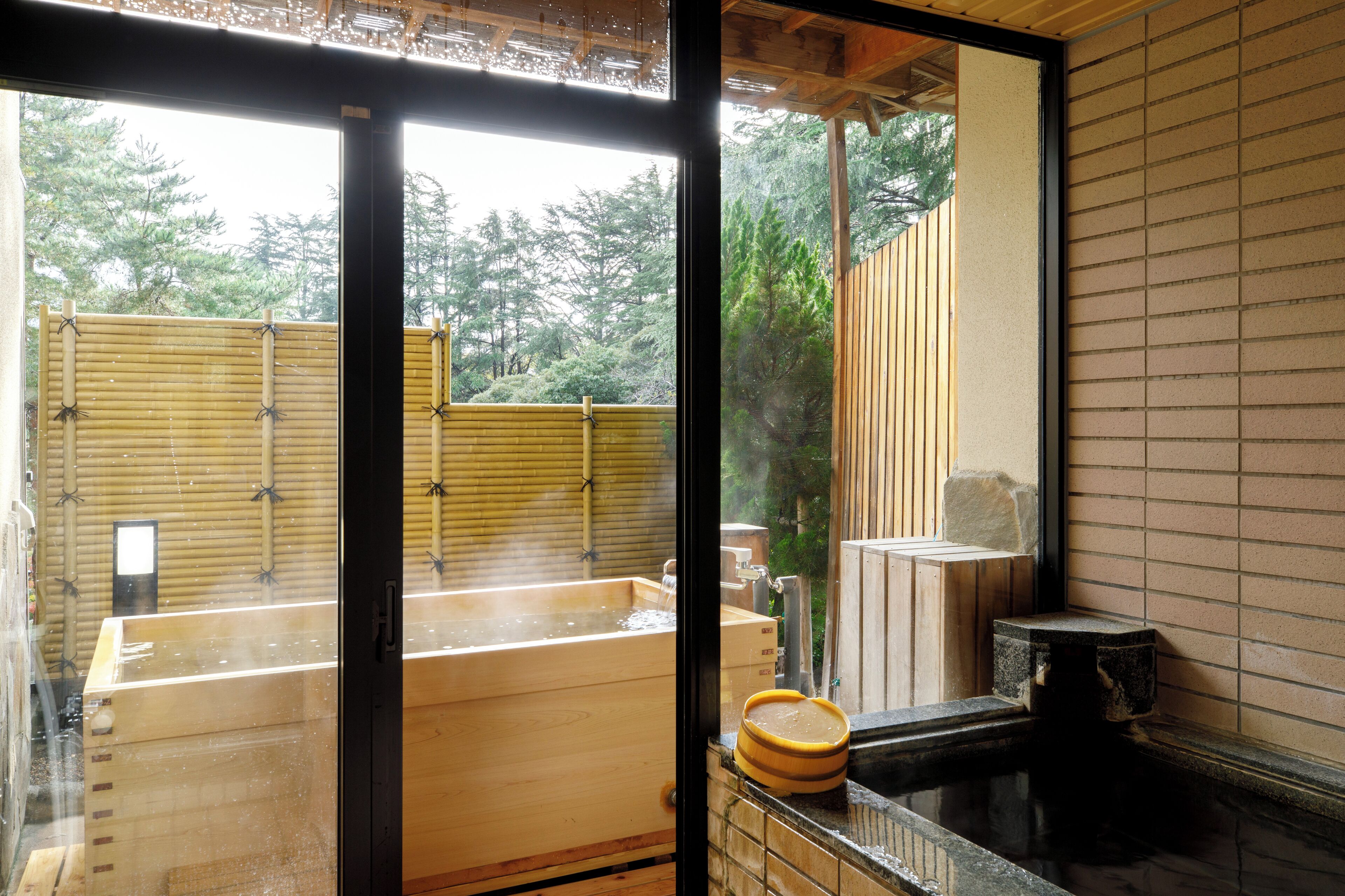 A traditional Japanese onsen with wooden tubs and a stone basin.