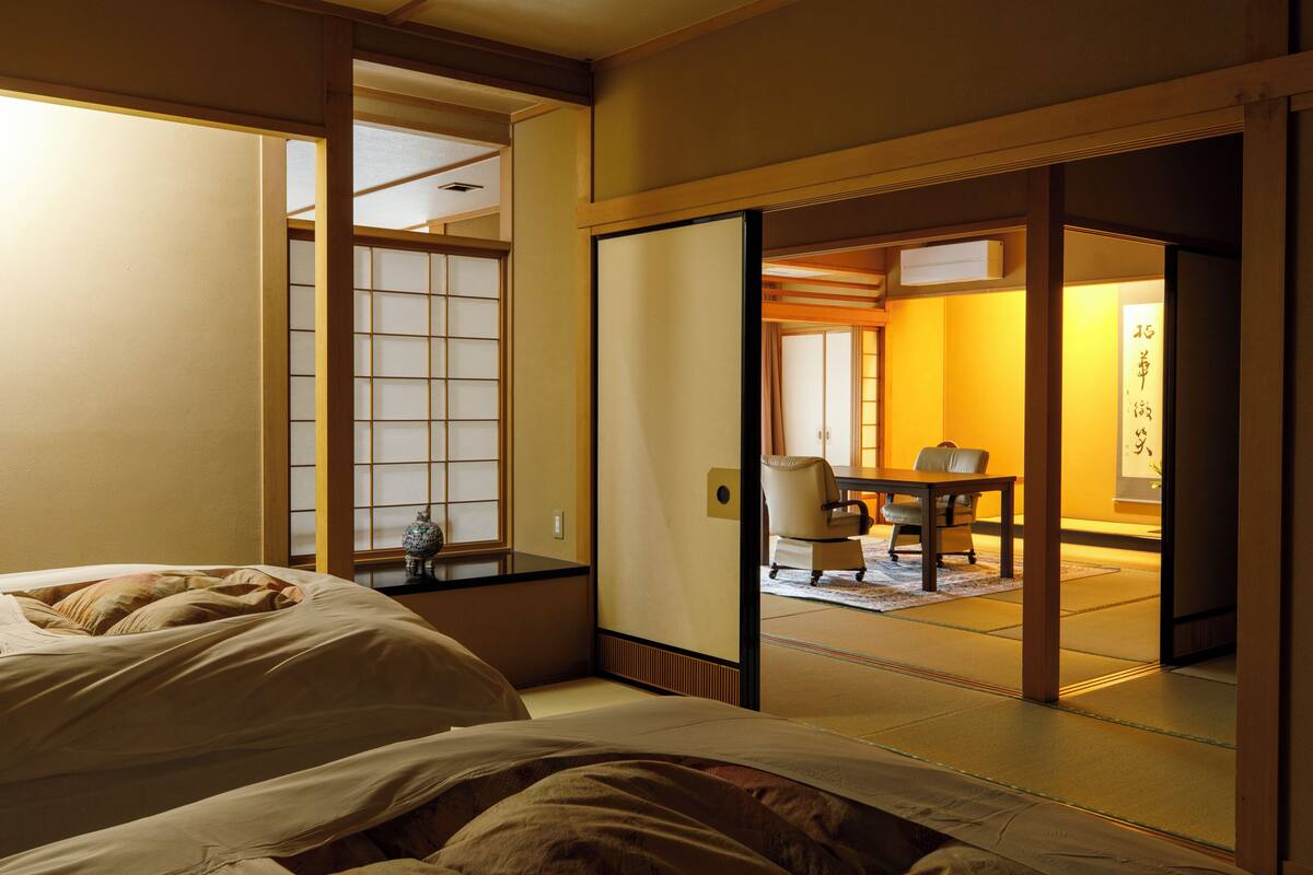 A traditional Japanese room with tatami flooring, a low table, and sliding doors.