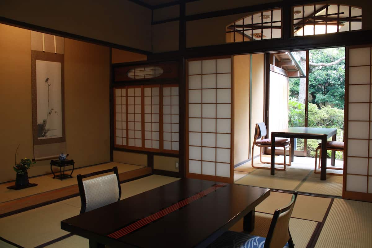A traditional Japanese room with tatami flooring, a low table, and sliding doors.