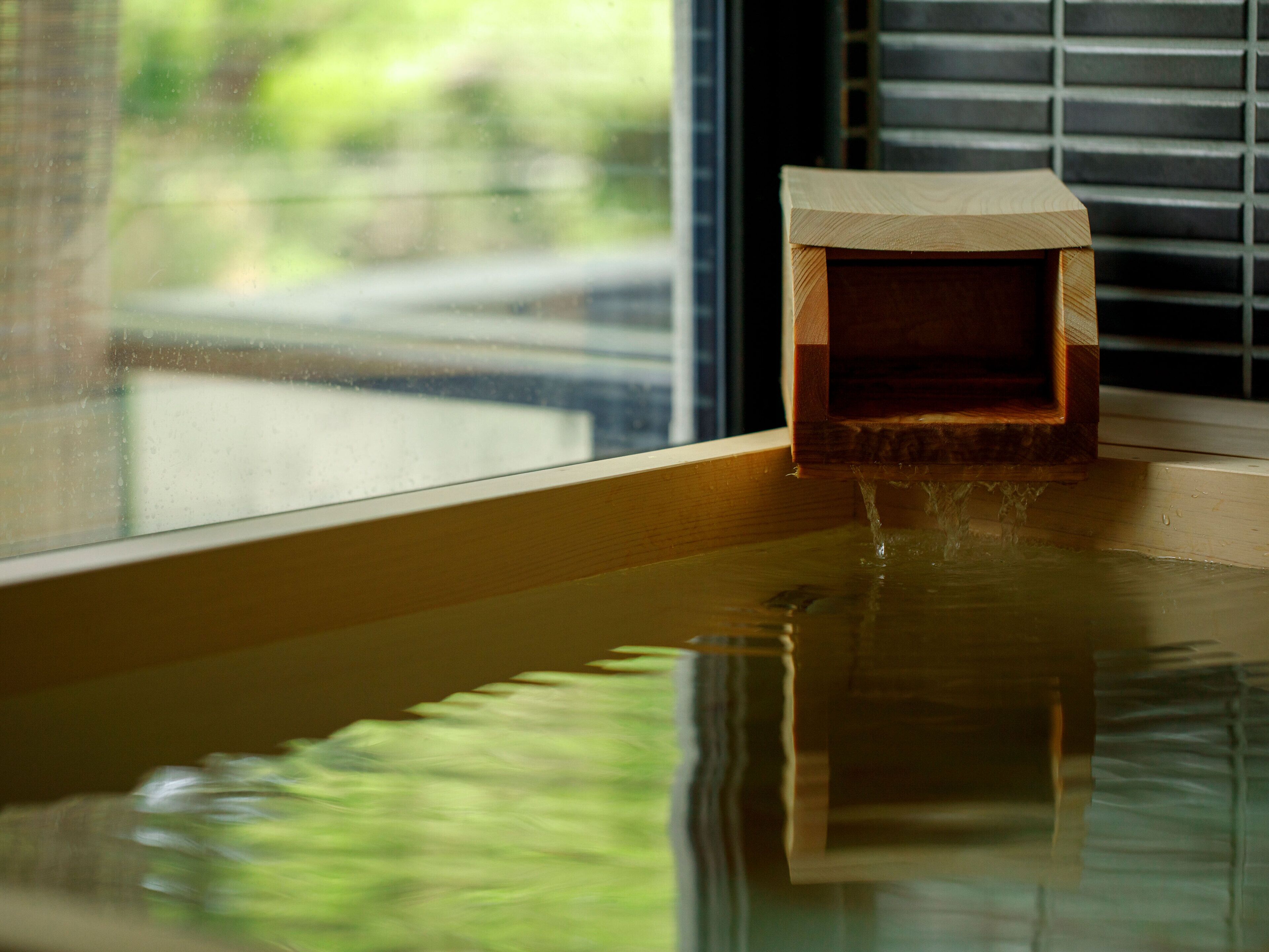 A wooden box with water flowing into a bathtub.