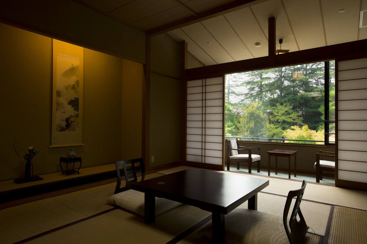 A traditional Japanese room with tatami flooring, a low table, and sliding shoji doors.