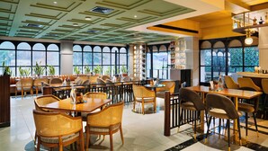 A spacious restaurant with high ceilings, large windows, and a variety of seating options including tables and booths.