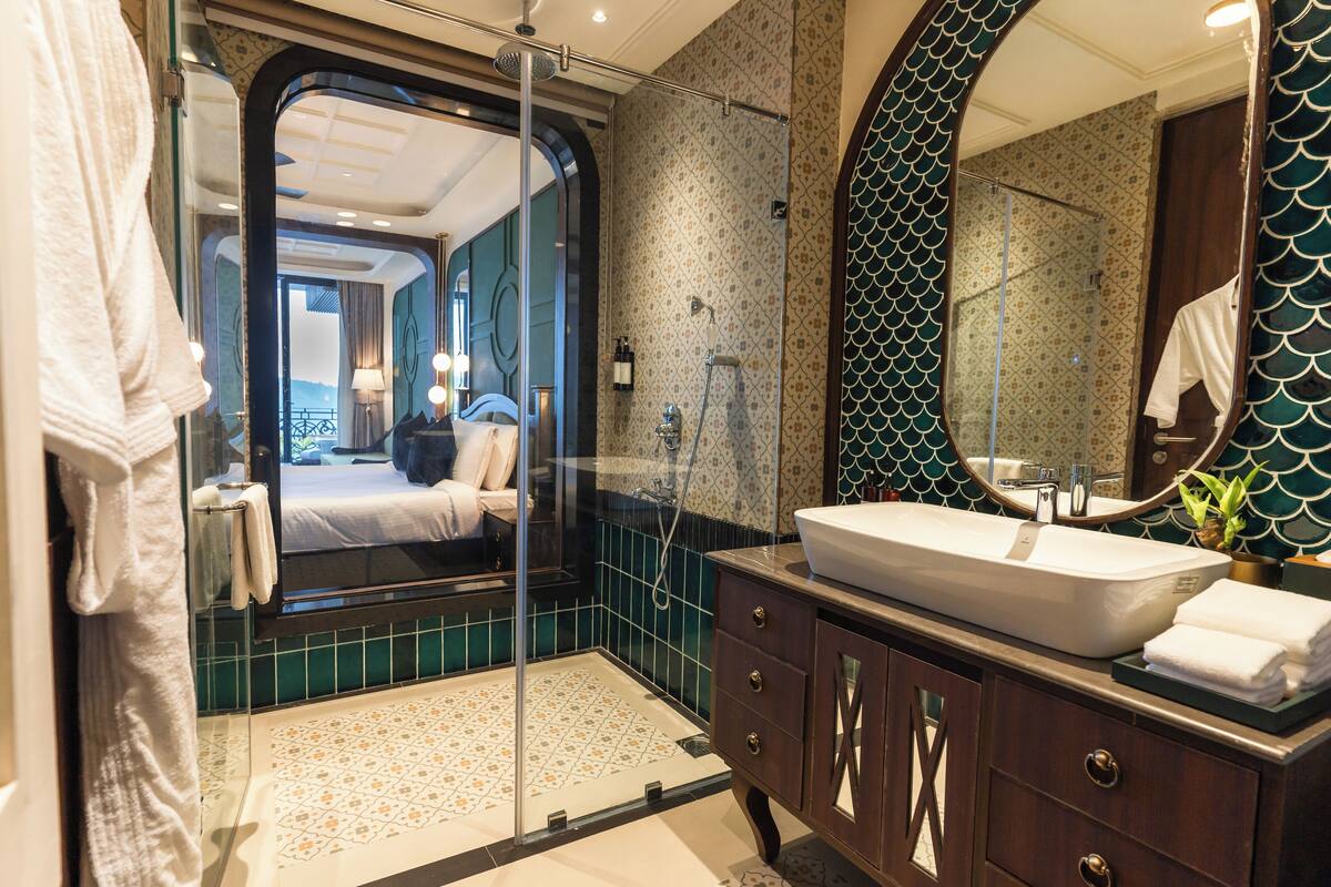Ein modernes Badezimmer mit einem großen Spiegel, einem weißen Waschbecken und einer Duschkabine.