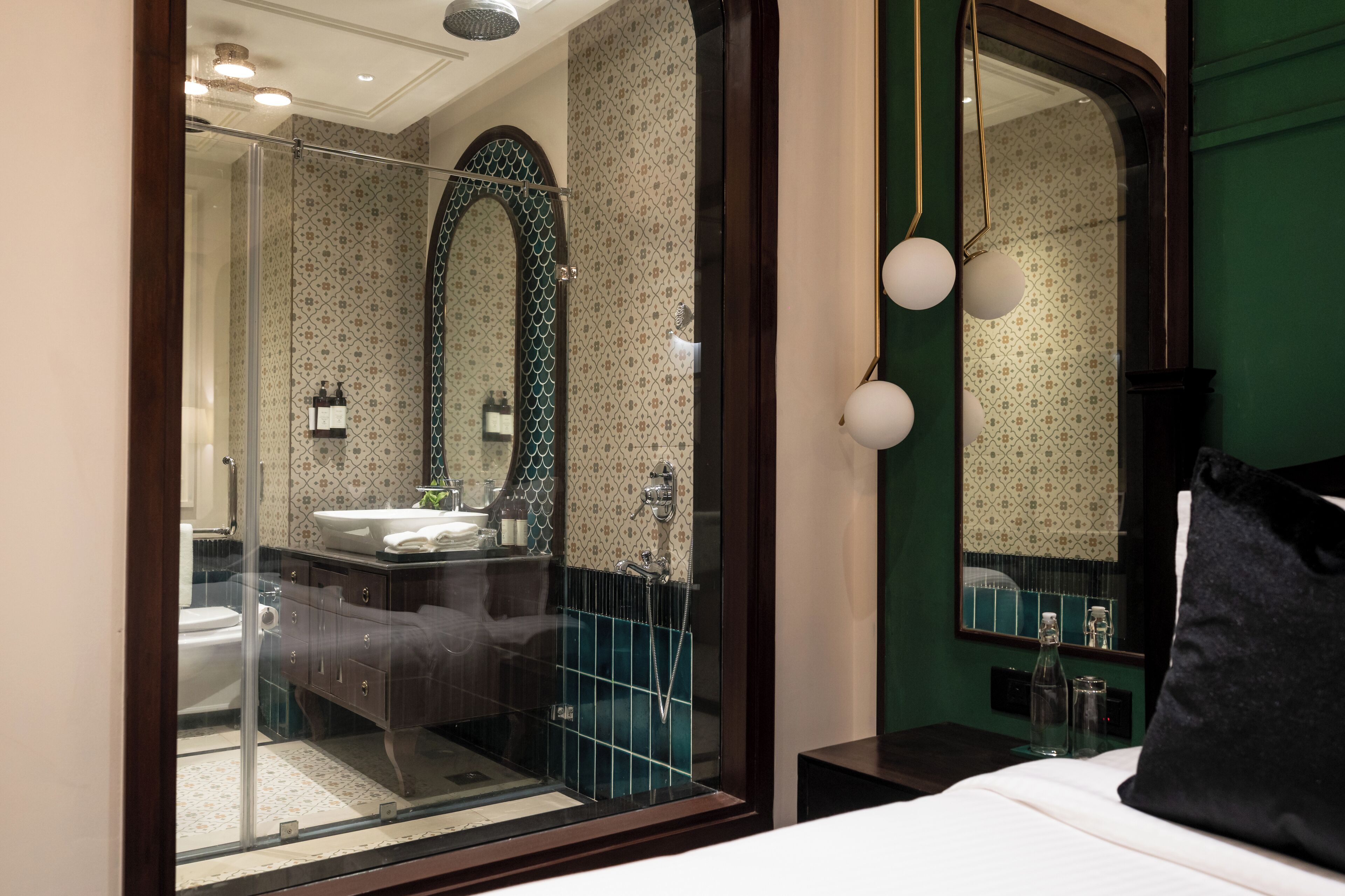 Une salle de bain moderne dotée d’une douche à parois de verre, d’un grand miroir et d’un lavabo agrémenté d’un pare-éclaboussures décoratif.