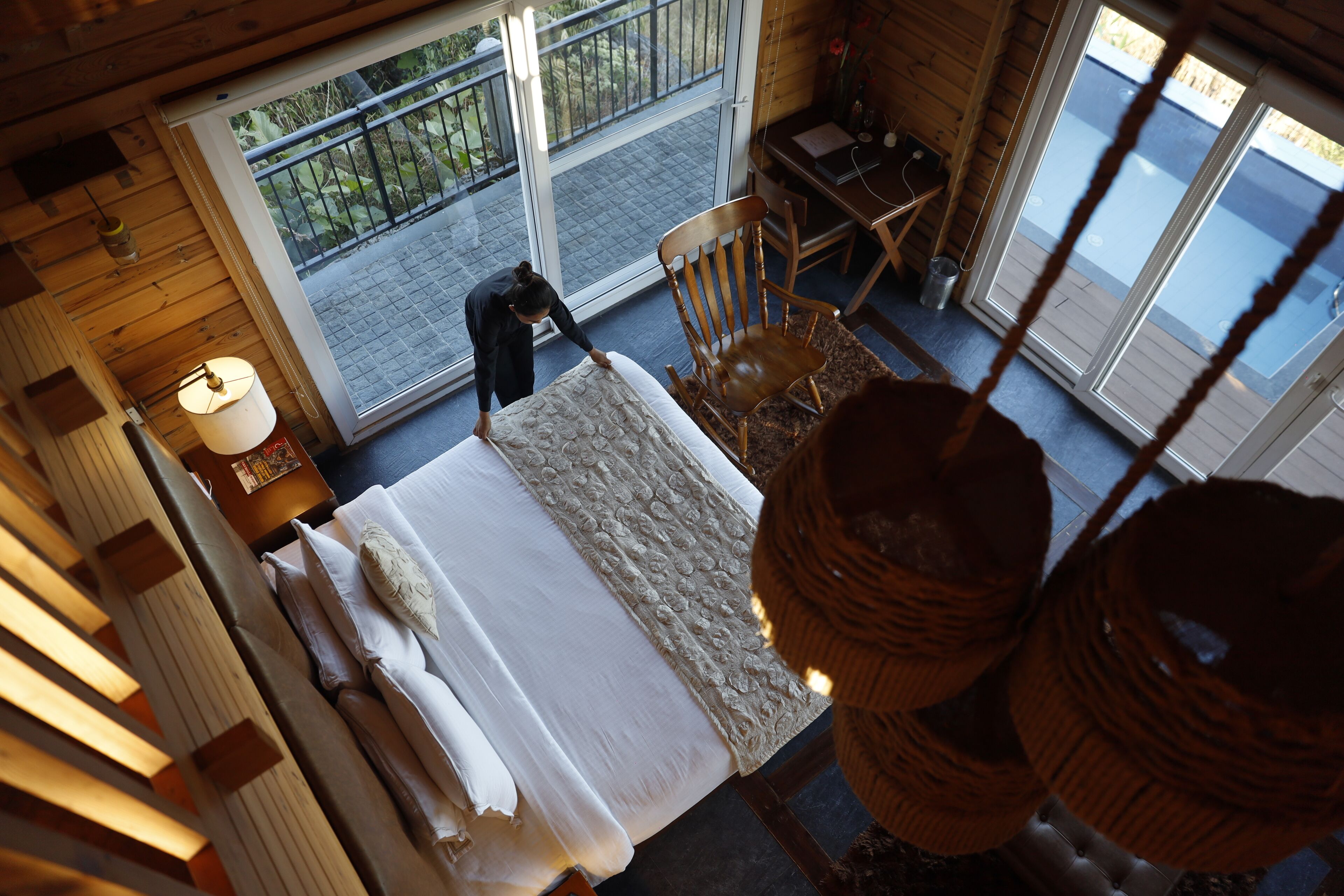 Una habitación con cama, una silla, una mesa y vistas al exterior.