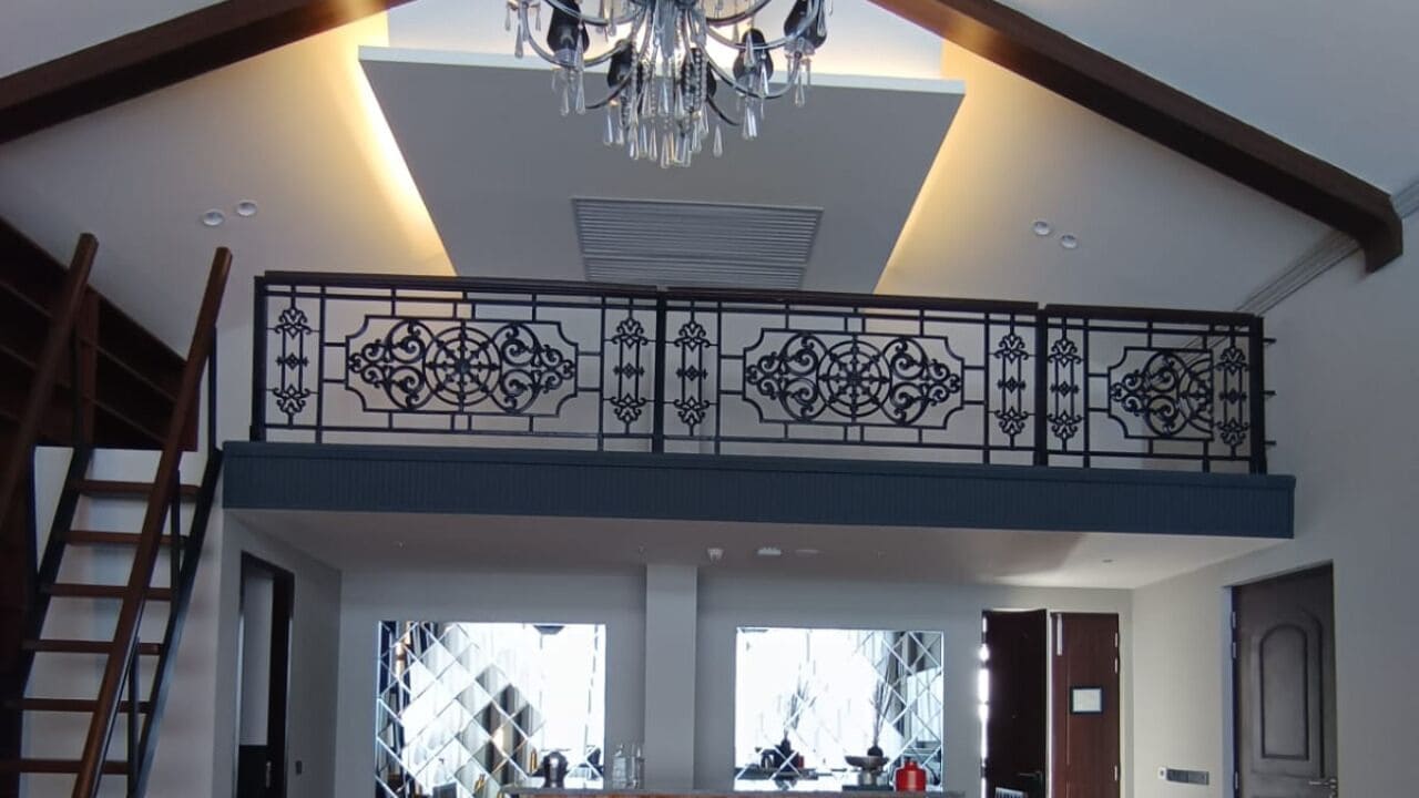 A room with a balcony, a chandelier, and a view of the outside.