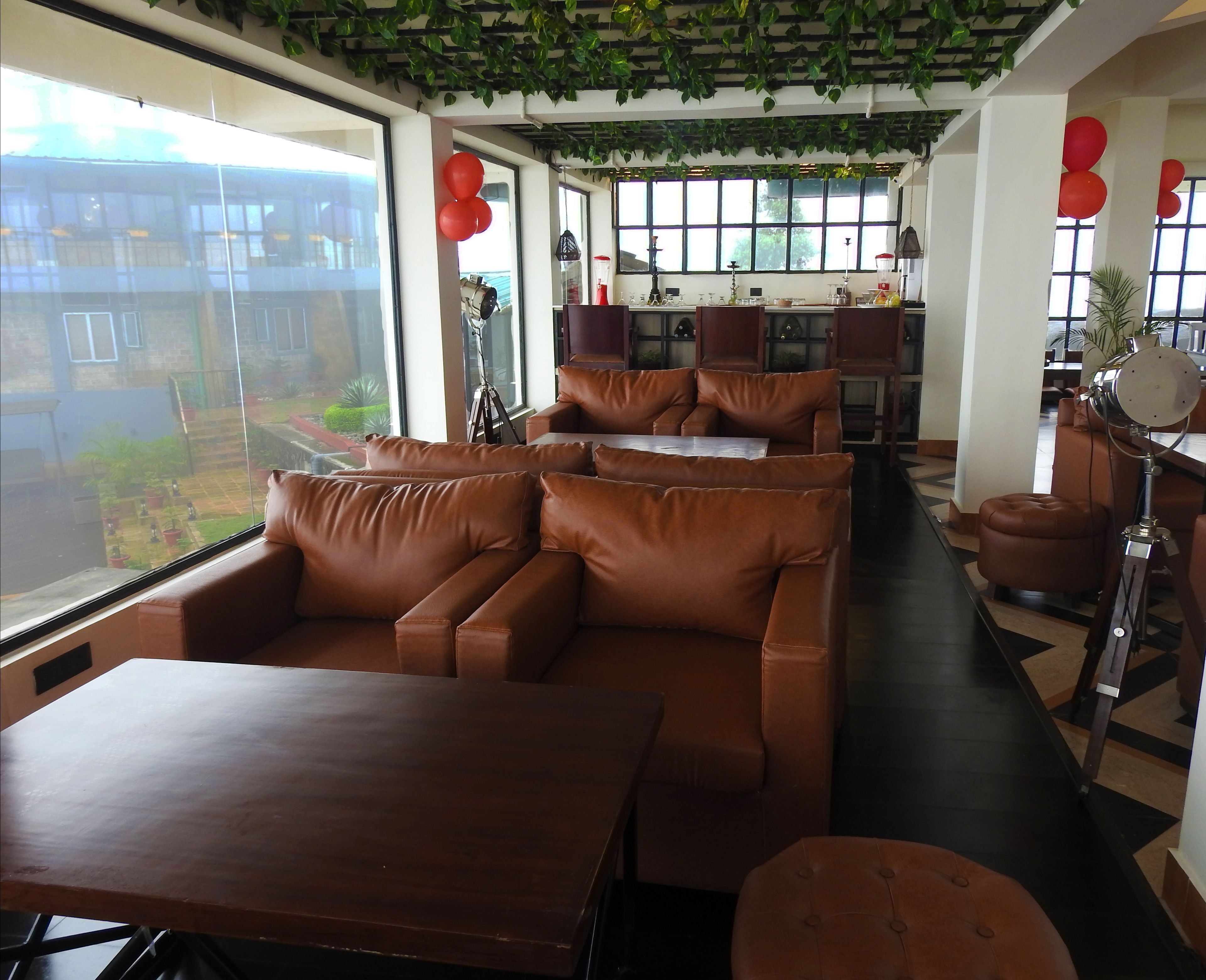 Ein modernes Interieur mit Ledersofas, einem Holztisch und einer Küchenzeile mit Barhocker.