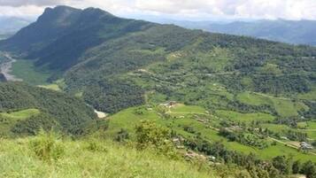 A mountainous landscape with a winding road and scattered buildings.