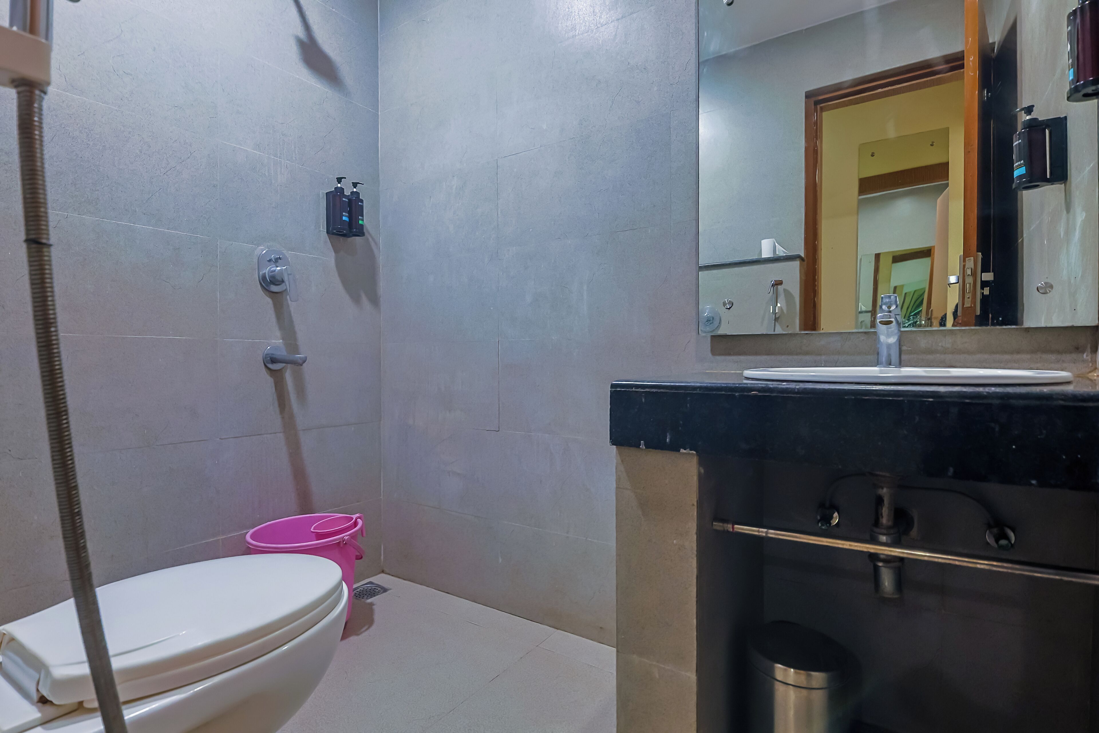 Un baño con inodoro, lavabo y espejo.