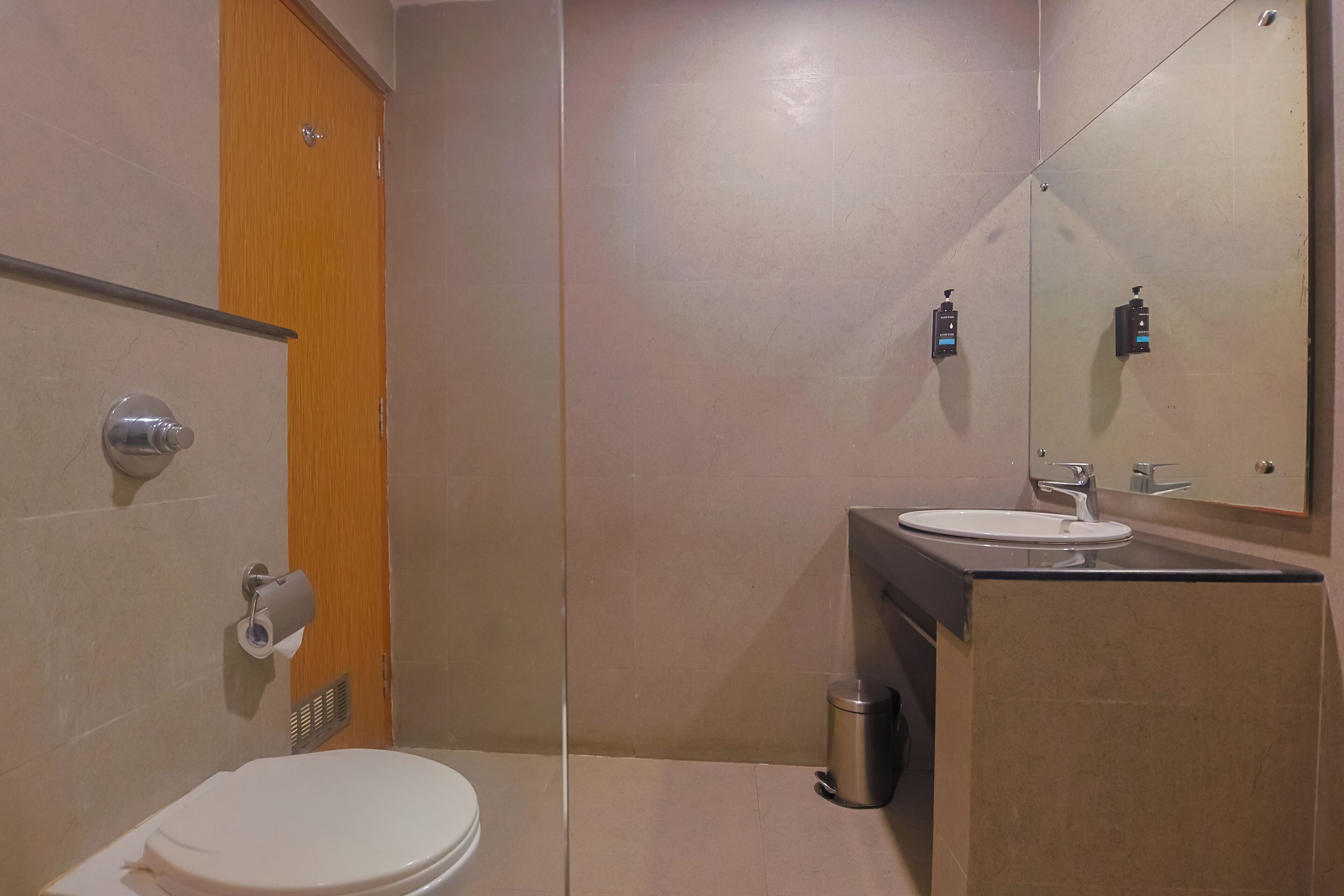 A modern bathroom with a toilet, sink, and mirror.
