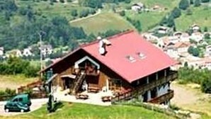 A chalet with a red roof, a wooden staircase, and a small porch area. - Green Park (Pokhara)