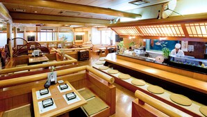 A traditional Japanese restaurant with wooden furniture, tatami mats, and a sushi bar.