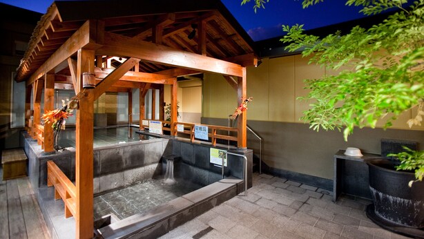 A traditional Japanese onsen with wooden structures and stone baths.