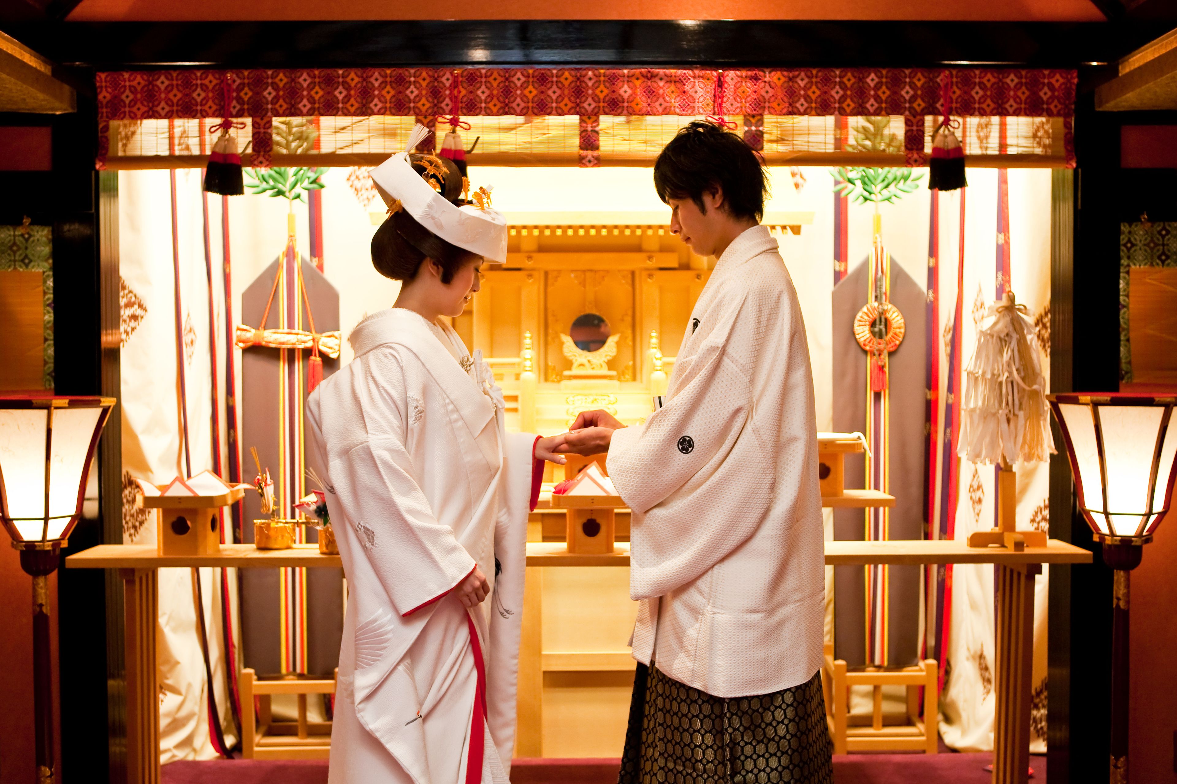 Un interior japonés tradicional con suelo de tatami, un mampara de papel shoji y una mesa de madera baja.