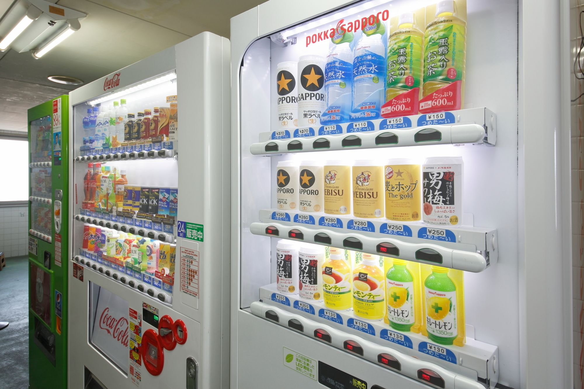 Vending machines stocked with beverages and snacks, including brands like Coca-Cola and Sapporo.