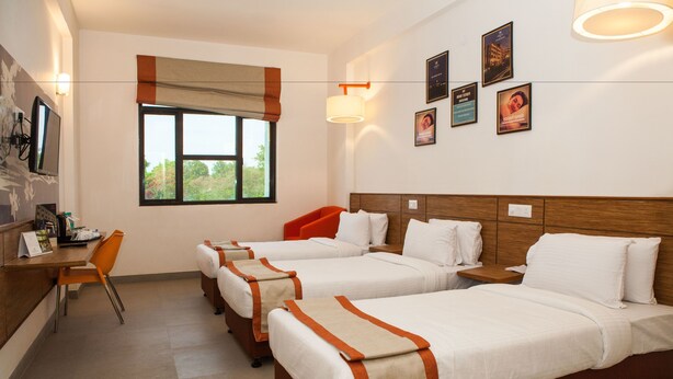 A hotel room with three beds, a desk, and a chair. - Max Hotels Jabalpur (Jabalpur)