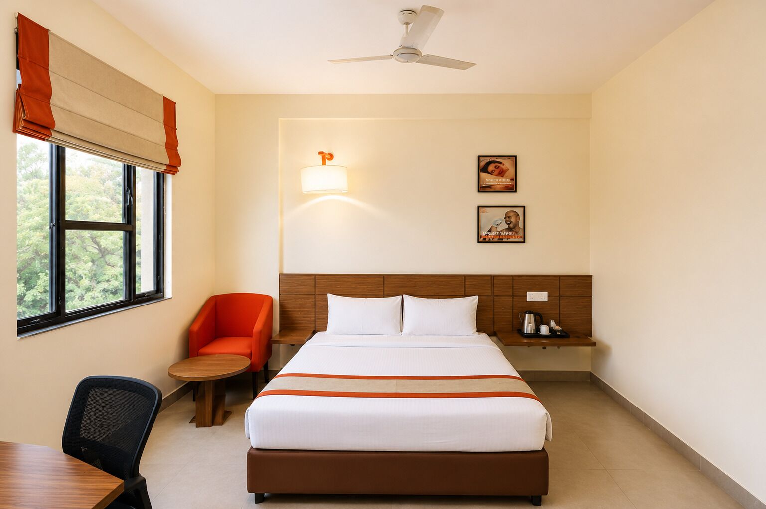 A hotel room with a bed, a desk, a chair, a nightstand, and a ceiling fan.