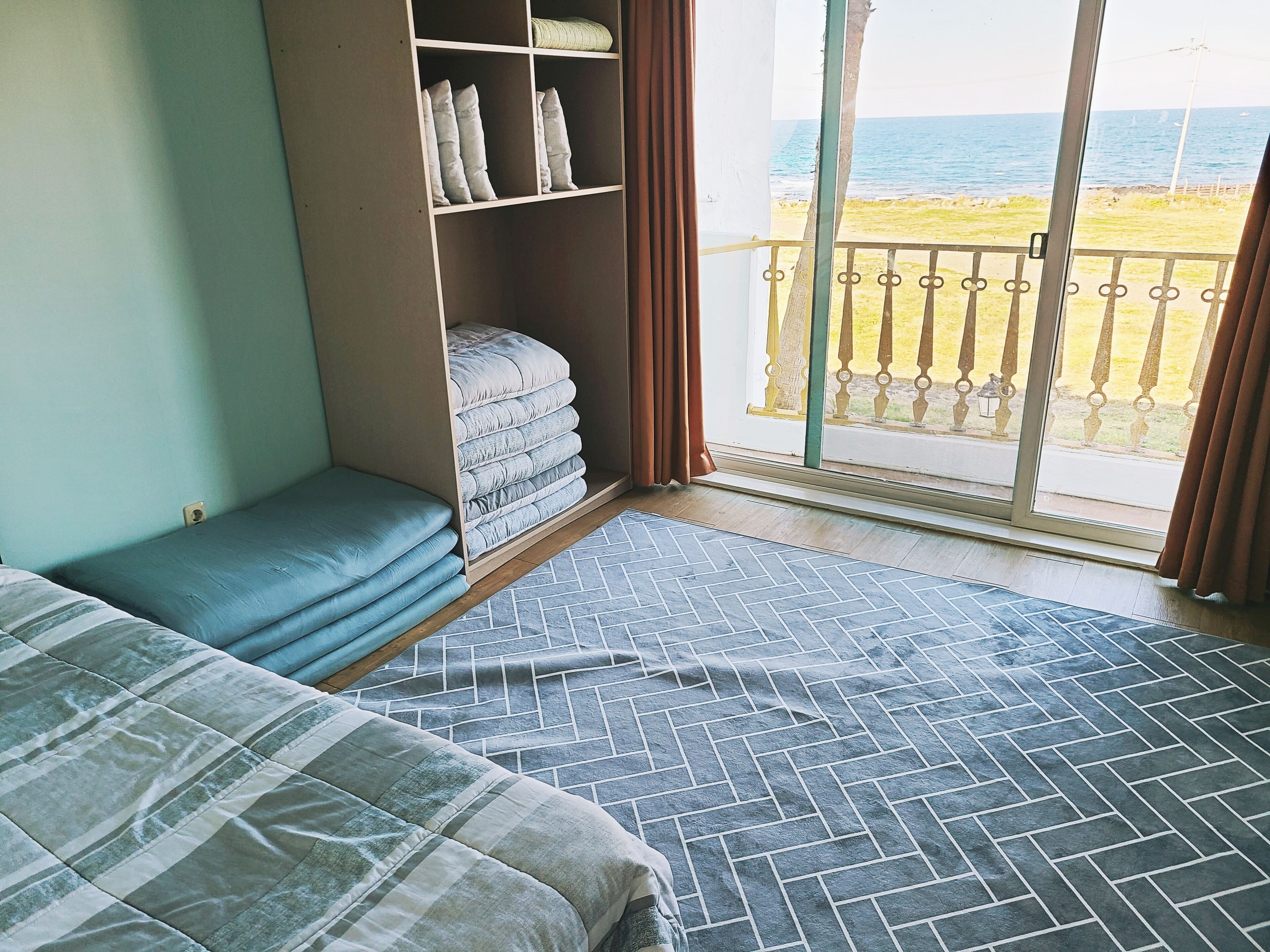 Ein Schlafzimmer mit zwei Betten, einem Einbauschrank und Meerblick.