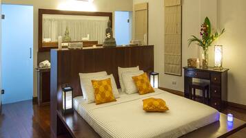 A spacious bedroom with a large bed, bedside tables, a desk, and a ceiling fan.