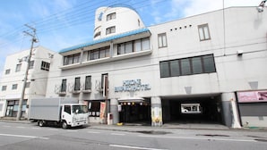 A building with a sign for "HIRONE BWA HOTEL" with a covered entrance and a parking garage. - Hikone Biwako Hotel (Hikone)