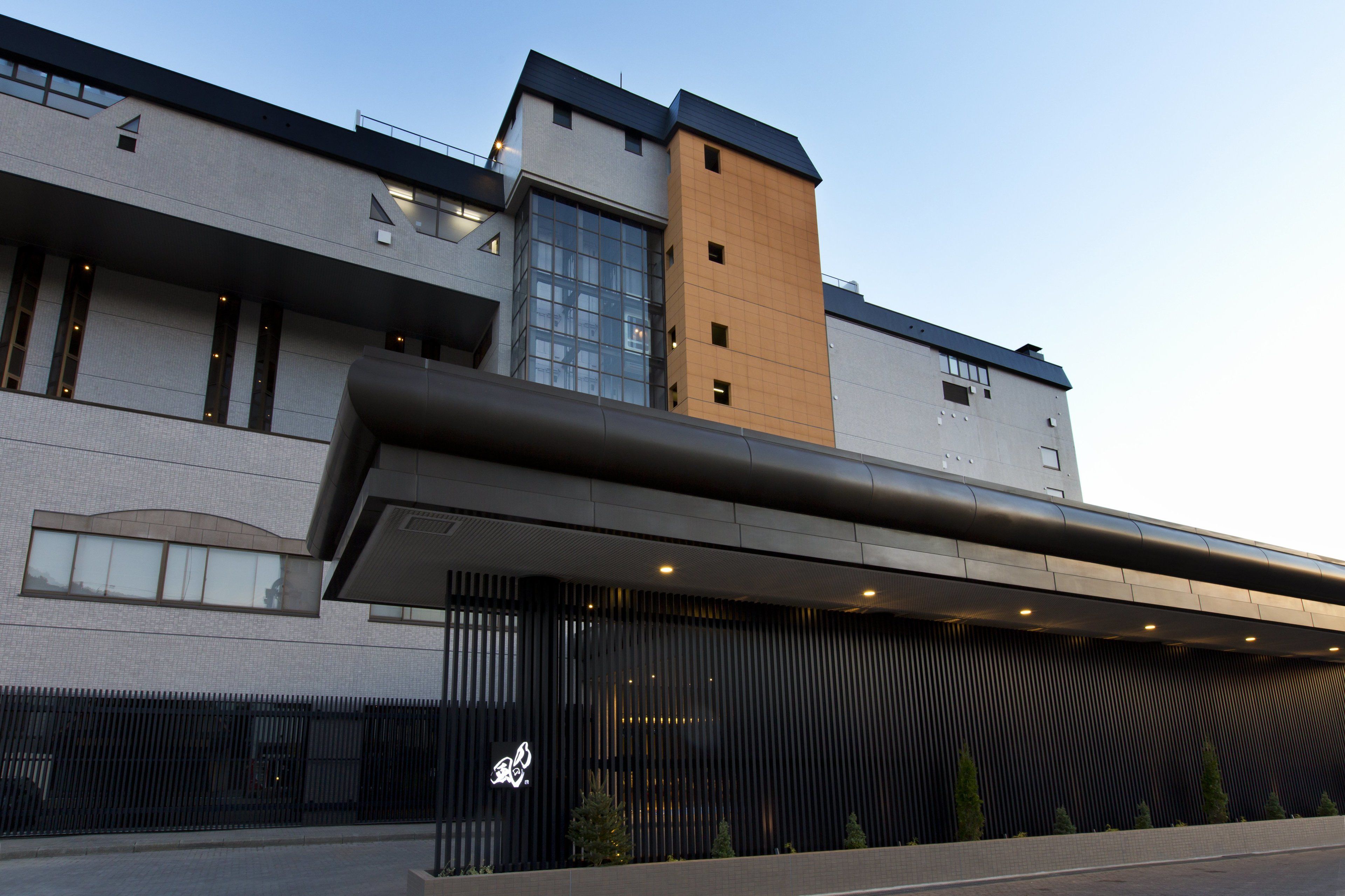 Un edificio moderno con tetto piatto, ampie finestre e una sezione verticale ben definita.