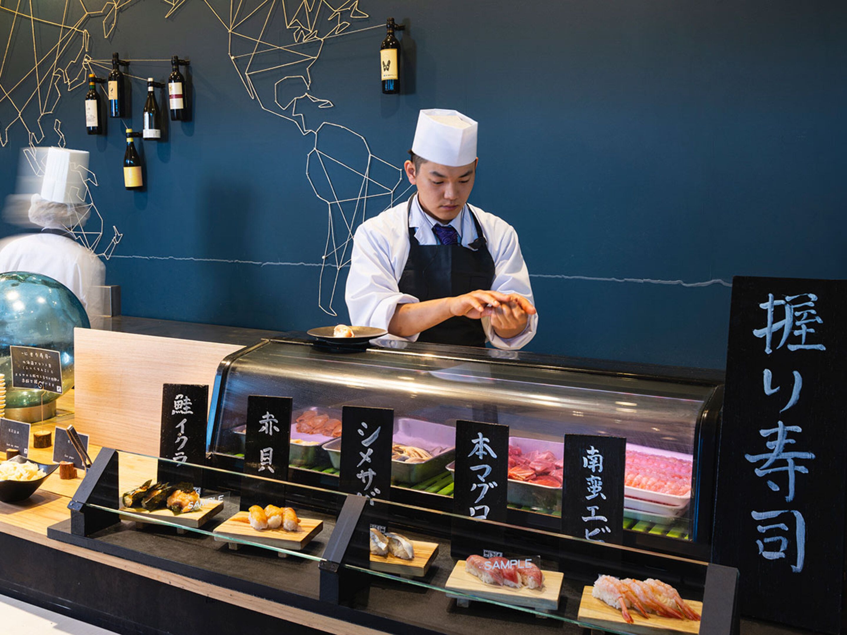 A sushi bar with various types of sushi displayed in front of the counter.