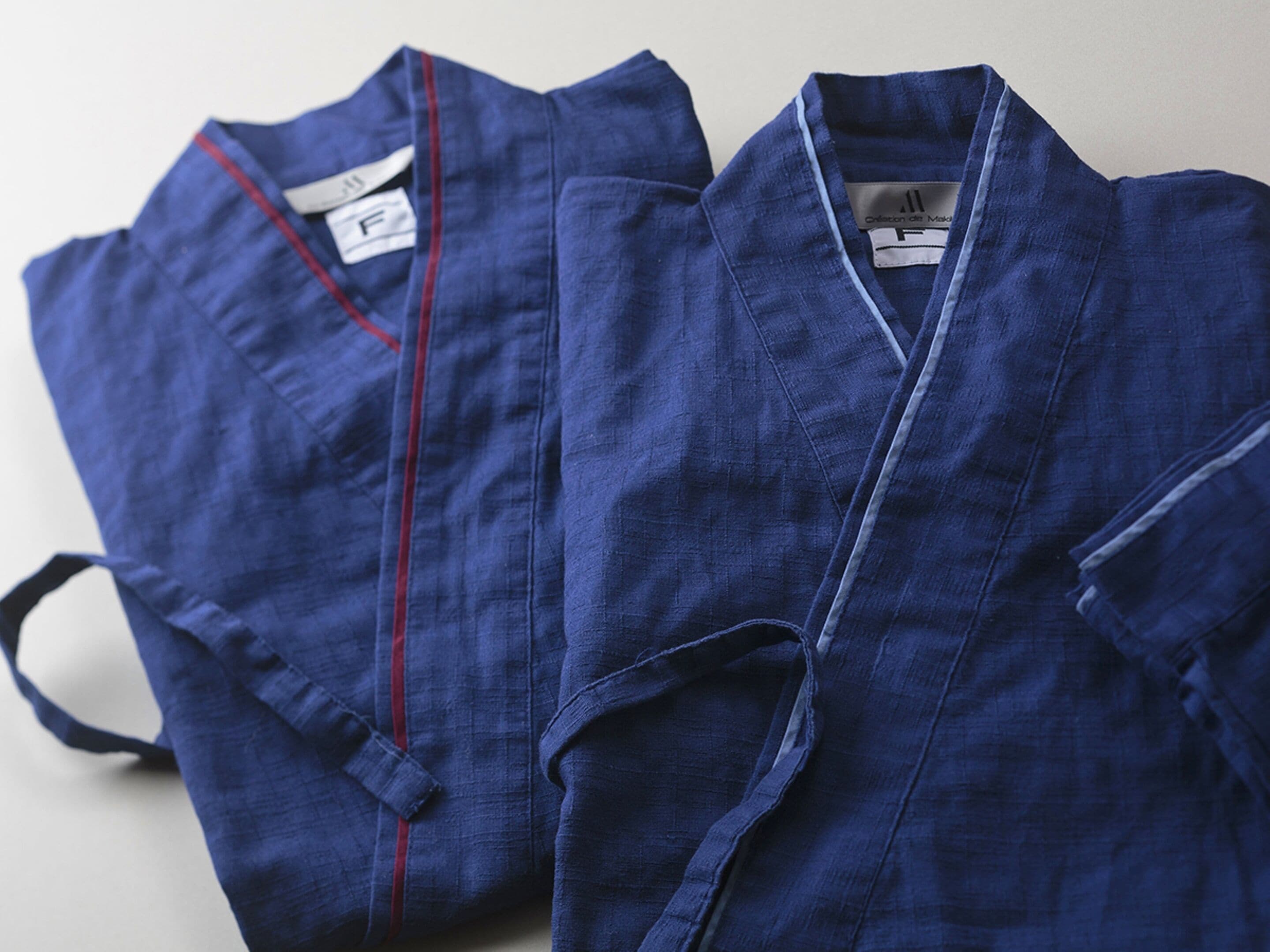 Two blue robes with red trim and a tag labeled "F".