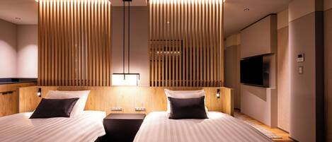 Een moderne hotelkamer met twee bedden, een flatscreen-tv en een wandpaneel van houten latten.