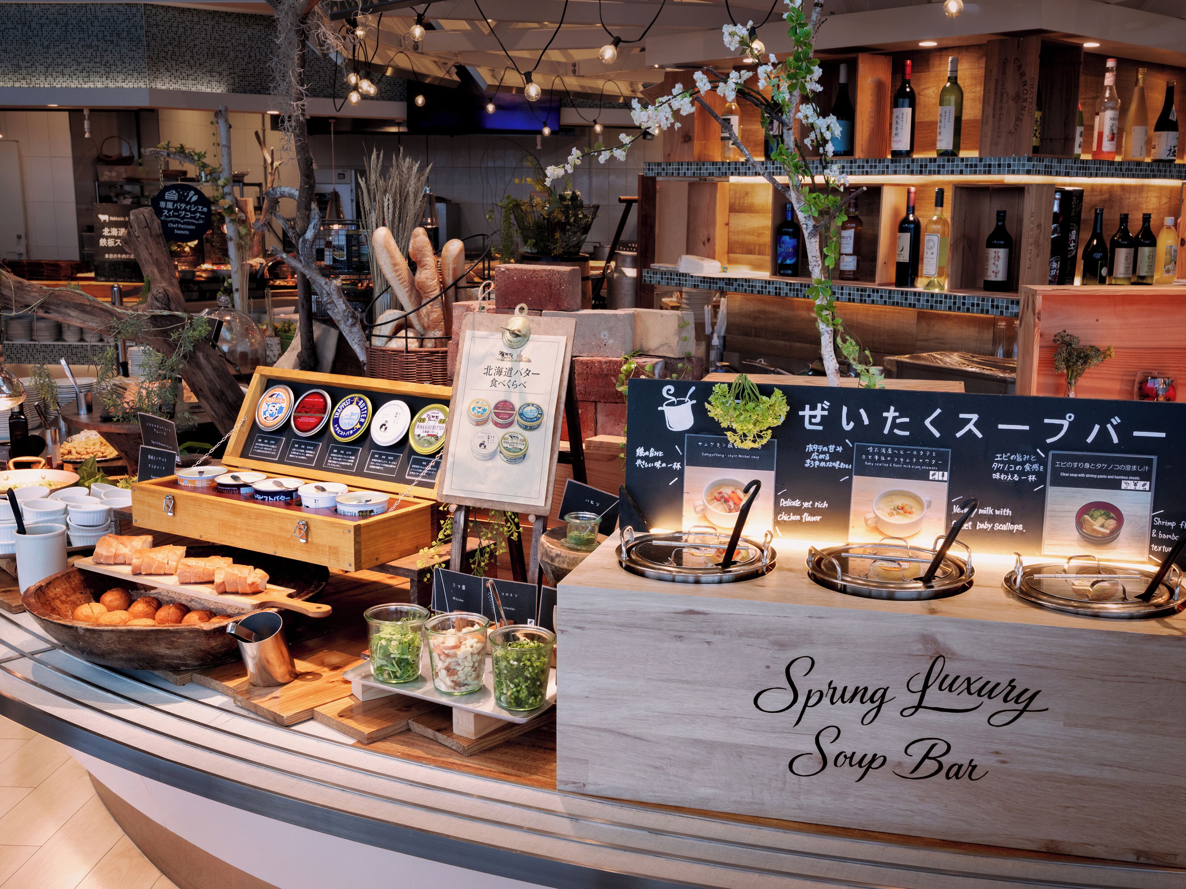 A buffet area with various food options, a selection of beverages, and a sign indicating it's a 'Spring Luxury Soup Bar'.