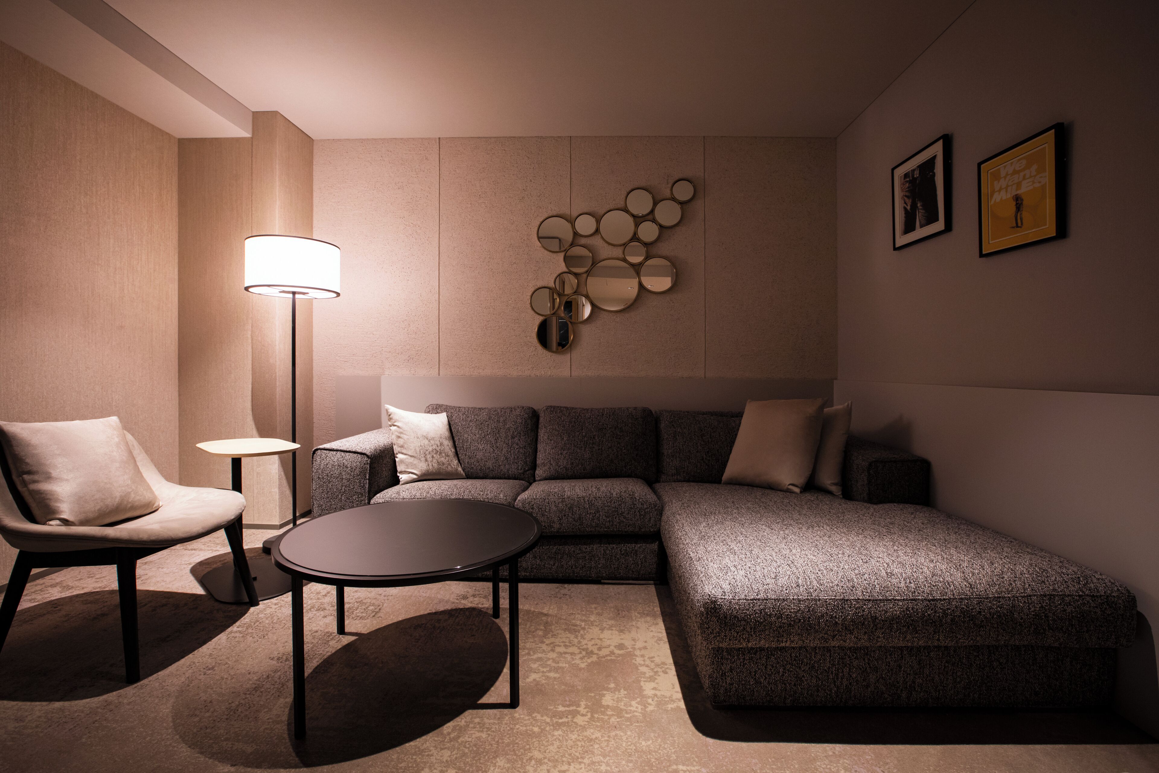 A modern living room with a sectional sofa, a round coffee table, and a floor lamp.