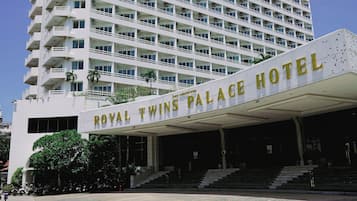 Ett hotell med flera våningar och en framträdande entré där det står: ”ROYAL TWINS PALACE HOTEL”.