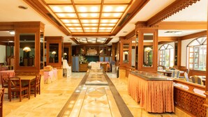 A hotel lobby with a central bar area, seating arrangements, and a decorative floor pattern. - Royal Twins Palace Hotel (Pattaya)