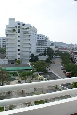 A multi-story hotel with balconies, a parking area, and a view of the surrounding cityscape. - Royal Twins Palace Hotel (Pattaya)