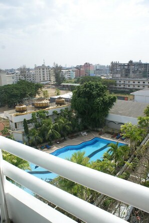 A rooftop pool area with palm trees and a view of surrounding buildings. - Royal Twins Palace Hotel (Pattaya)