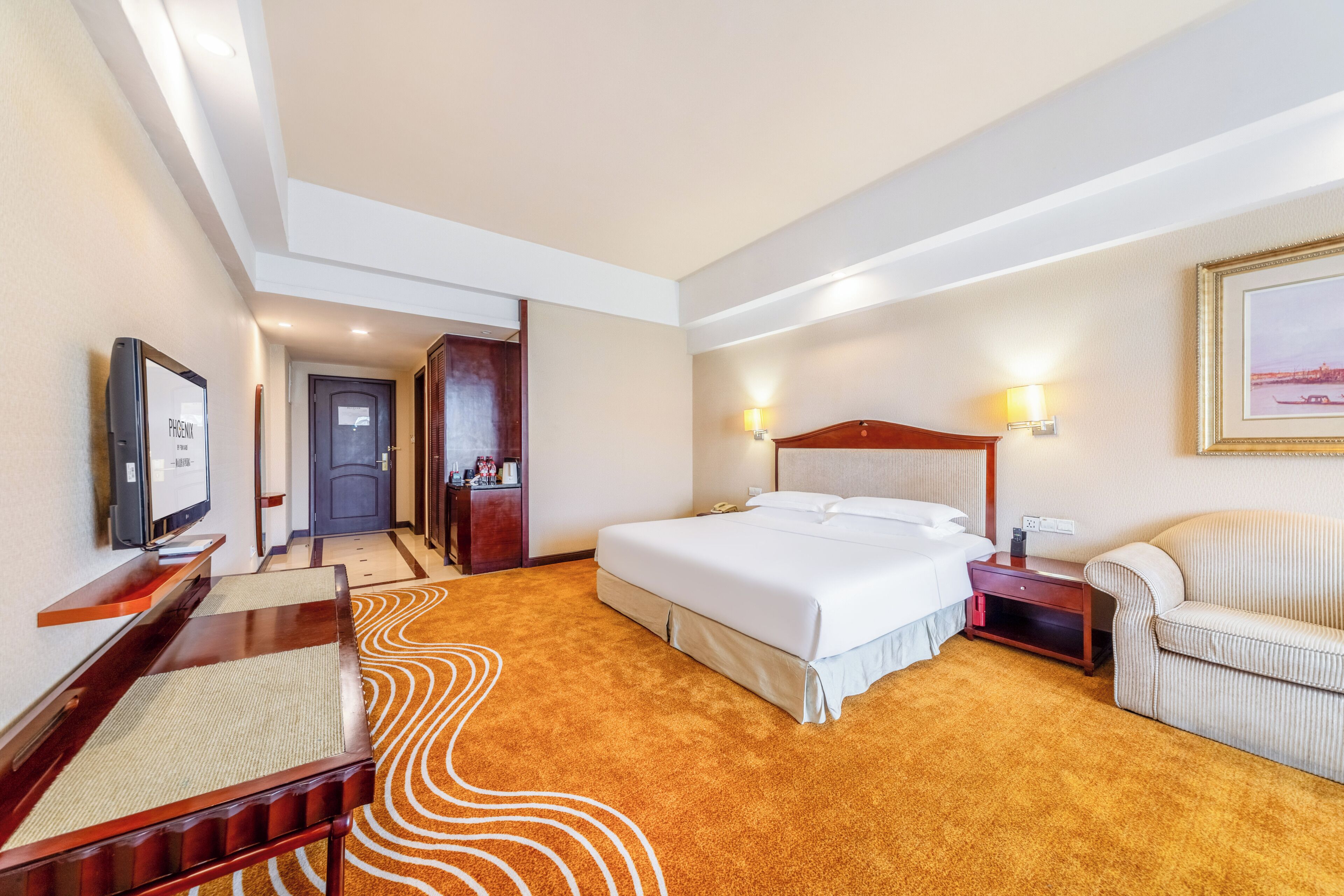 Une chambre d’hôtel avec un grand lit, une télévision, un bureau et une chaise.