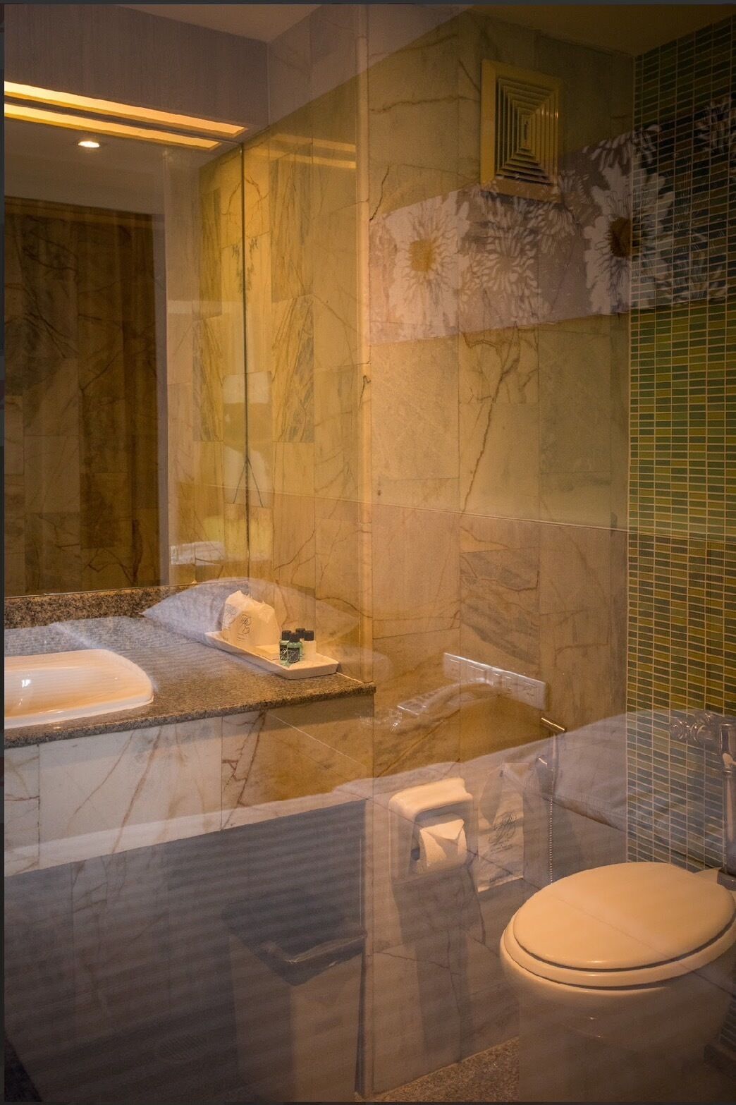 Uma casa de banho moderna com lavatório de mármore, banheira e sanita.