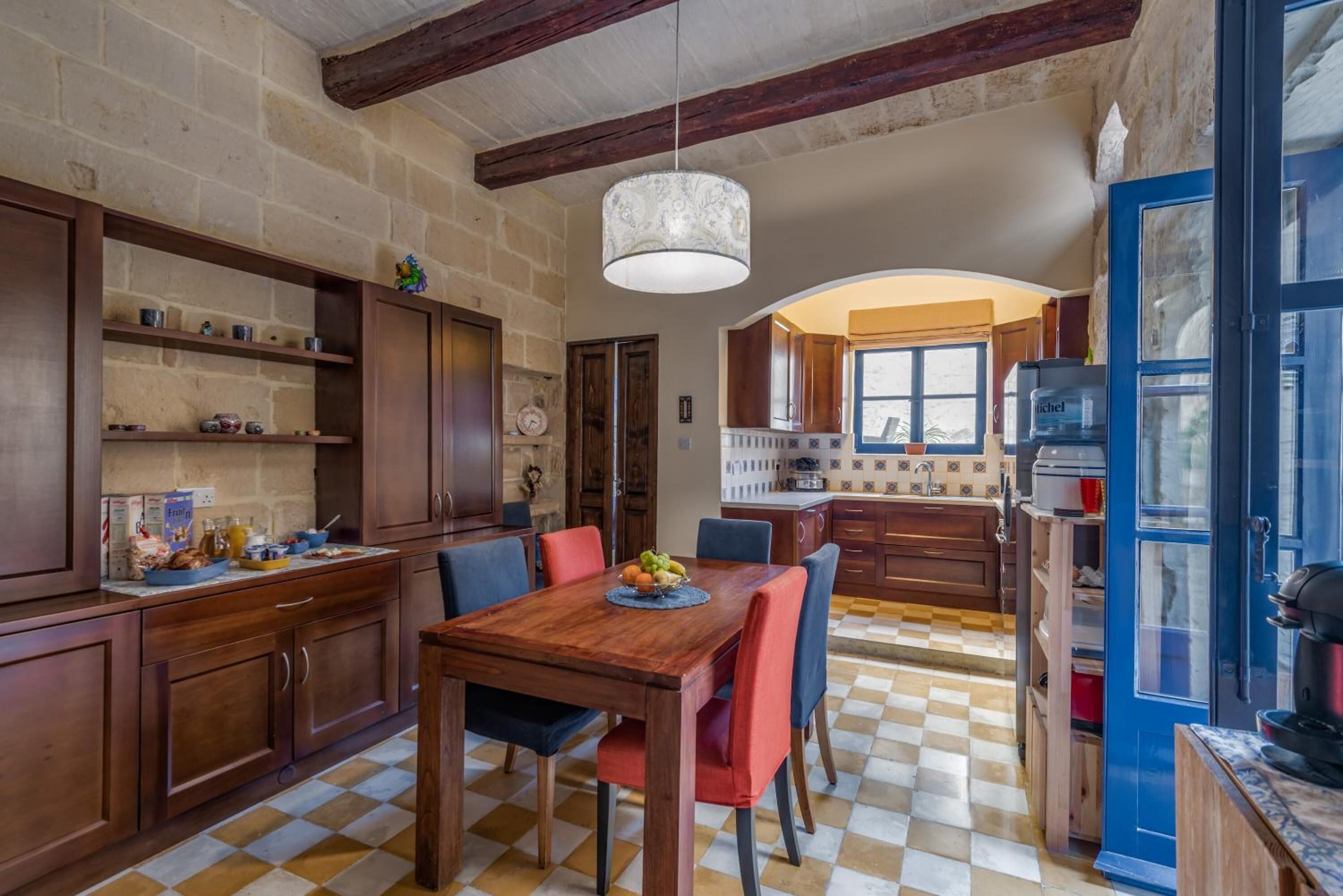 Un'ampia cucina con mobili in legno, pavimento a scacchi e lampadario.