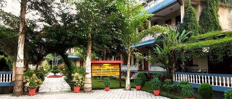 Experience the serene surroundings of Chitwan National Park from the resort's balcony overlooking lush greenery.