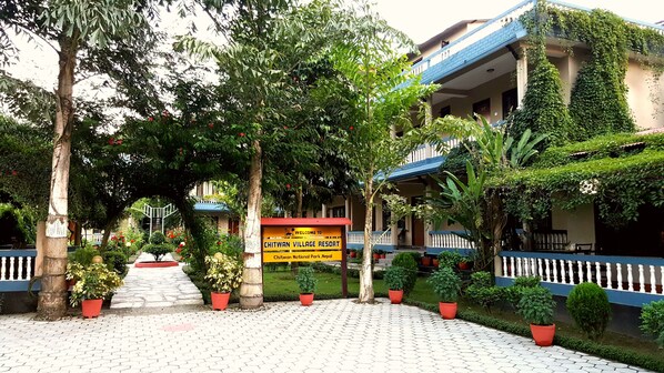 Una señal de bienvenida a los visitantes del Chitwan Village Resort, que indica su ubicación en el Parque Nacional de Chitwan, Nepal.
