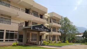 A multi-story hotel with a sign reading "Hotel Polo Orchid." - Polo Tura Hotel (West Garo Hills)