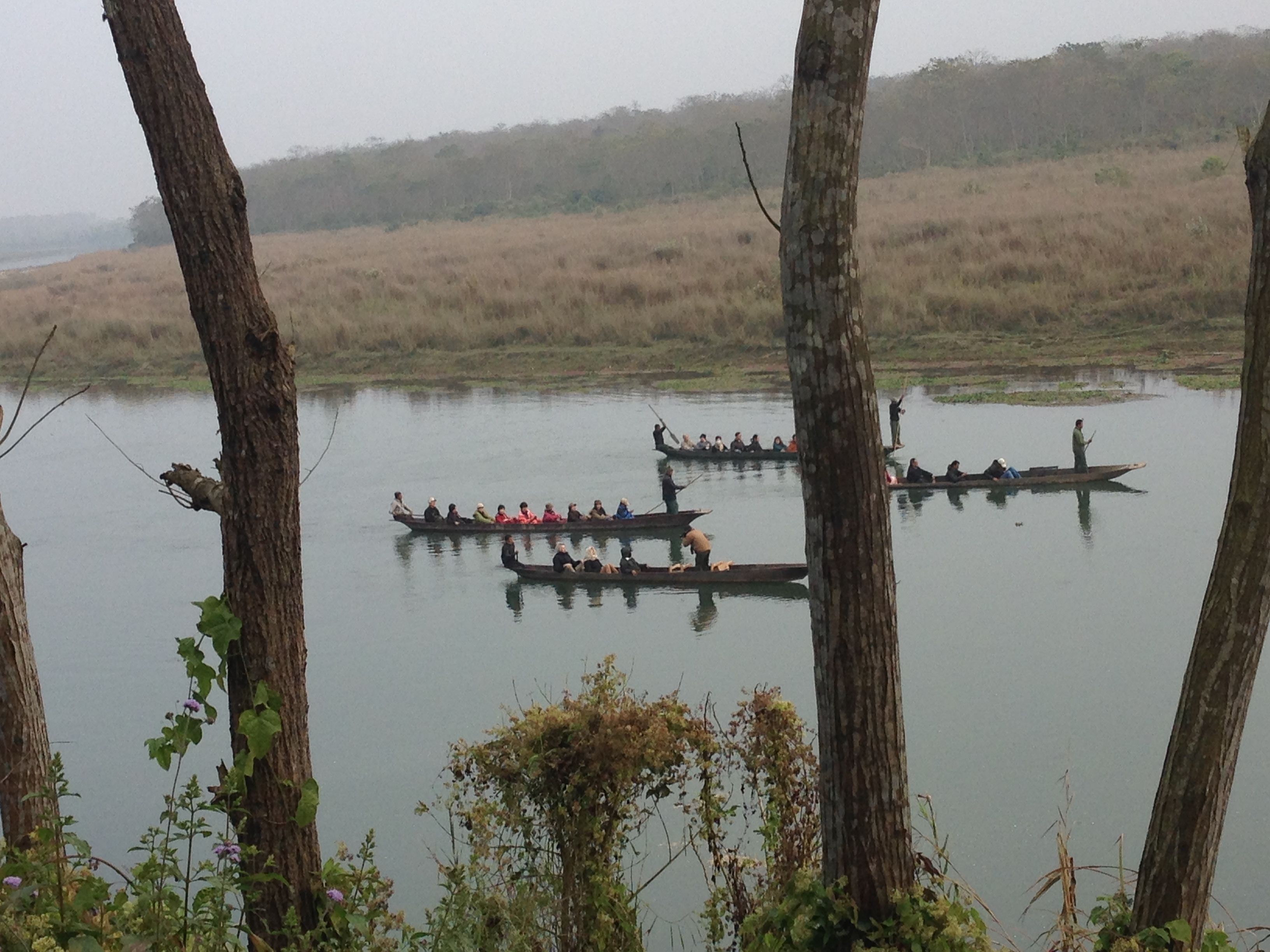 A calm river with several boats carrying passengers.
