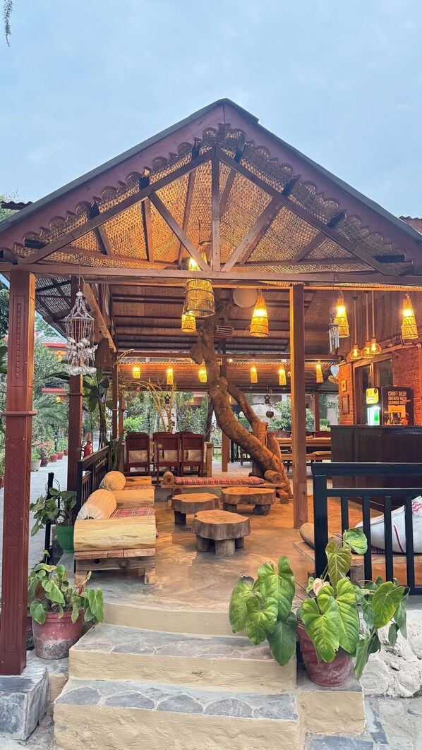 Un espacio de estar al aire libre con mobiliario de madera y escalones de piedra que lo llevan.