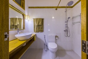 A bathroom with a white sink, a toilet, a shower, and two towels hanging on the wall. - Ameera Maldives (Dhiffushi)