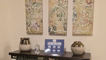 Une table ornée de vases décoratifs et d’un panneau indiquant les consignes de sécurité sanitaire.
