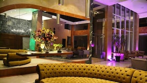 A lobby with a large yellow sofa, a floral centerpiece, and a modern interior design. - Delora Hotel and Suites (Chtaura)