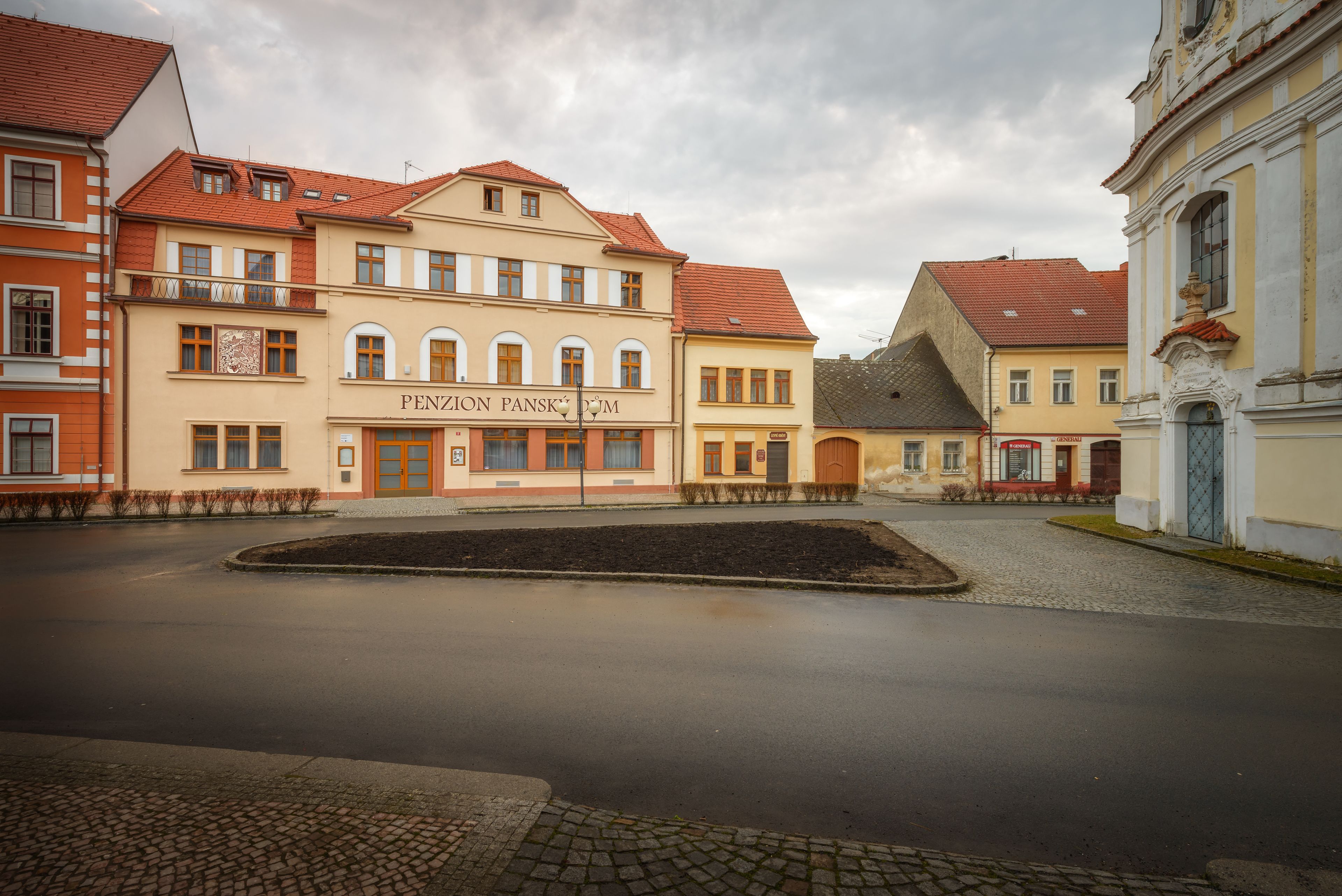 A street with buildings, including a building with a sign that reads "Penzion Pansky."
