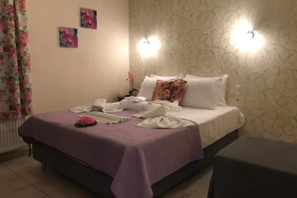 A bedroom with a bed, a bedside table, and a nightstand.